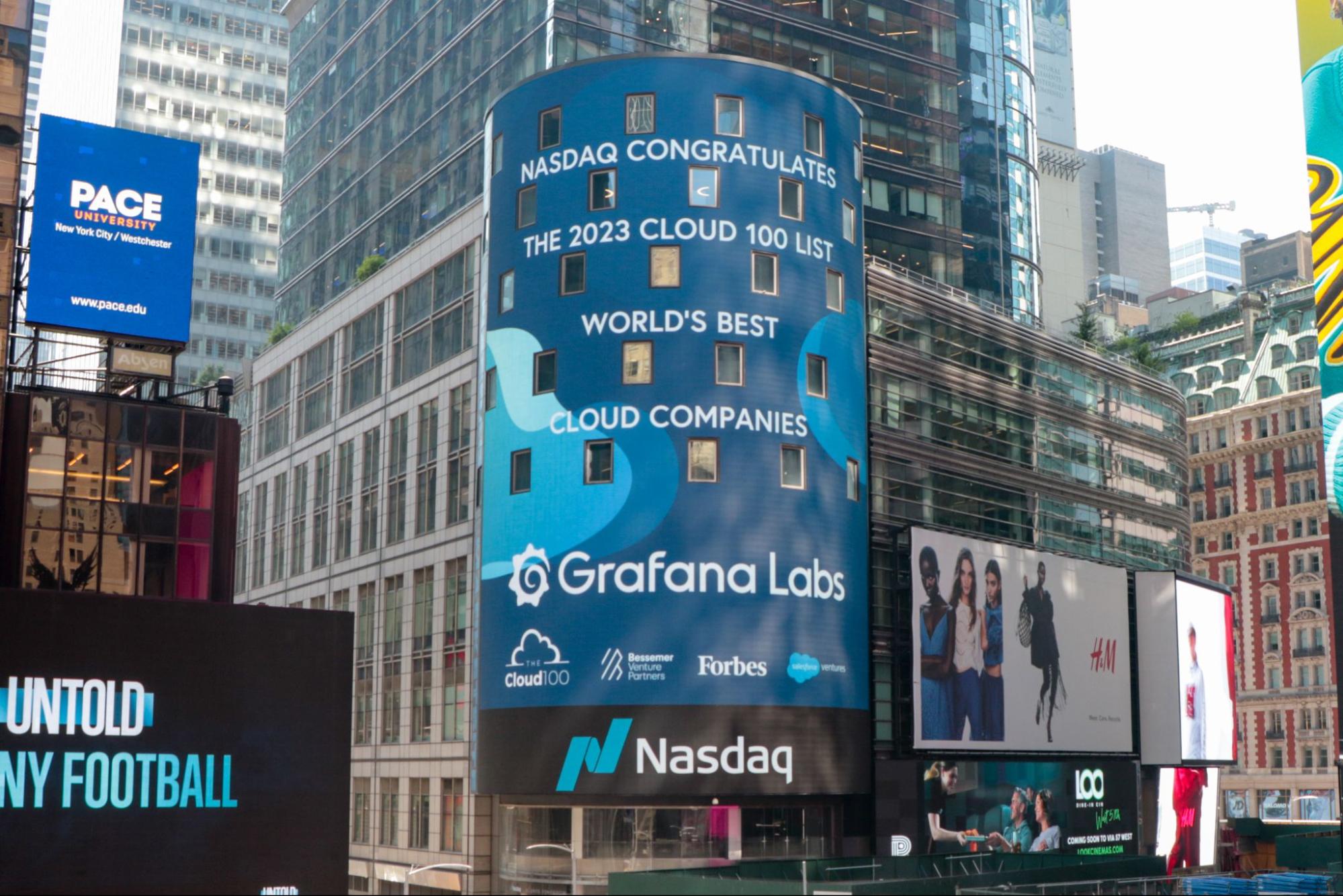 A photo of Grafana Labs listed on the Forbes 100 list on the Nasdaq Tower.