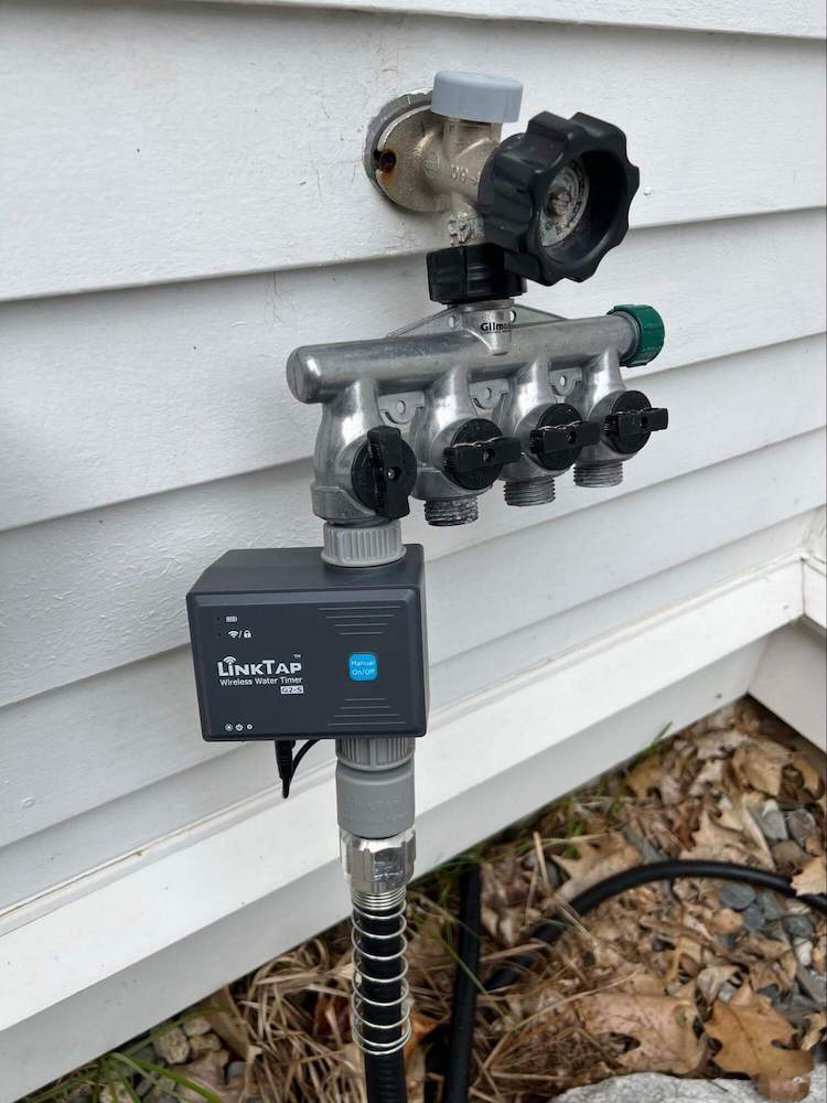 A picture of the LinkTap device attached to a spigot outside my house.